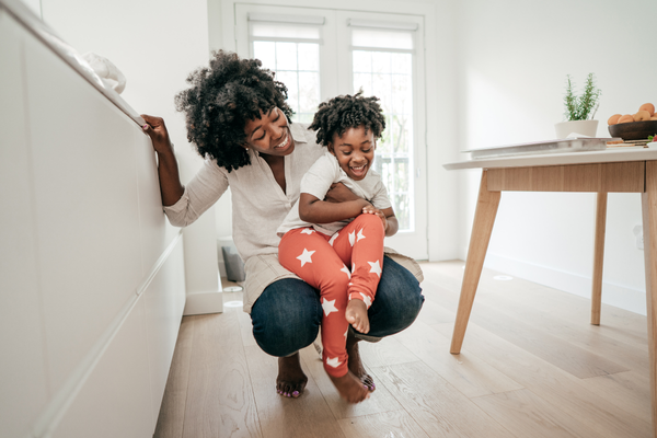 What should I look for in a new home? Fischer Homes. Adult and child playing in living room of home.