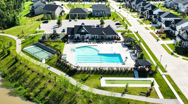 Community amenities at the Streets of Caledonia include a resort-style pool and active outdoor spaces designed for everyday living. Residents have access to an Olympic-size pool with a splash area and covered pavilion, along with tennis and pickleball courts, plus features like a clubhouse, fitness center, playground, and scenic walking trails around lakes and green space. 